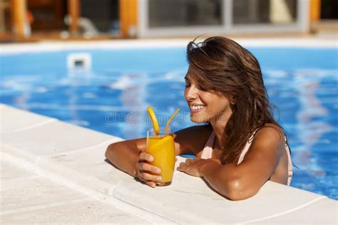 Mujer Tomando Un Cóctel Y Relajándose En La Piscina Foto de archivo