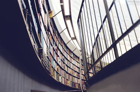 Books On Shelves Mounted Along A Curved Library Wall Curved Library