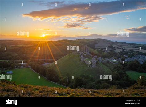 Sunrise With Sunburst Over The Dorset Countryside With Corfe Castle And