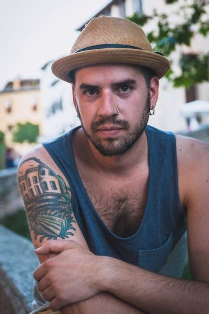 Retrato De Un Hombre Con Sombrero Sentado En Un Muro De Contenci N En