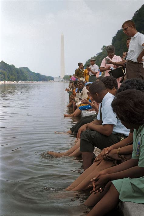 Demonstrators Sit With Their Feet In The Reflecting Pool During The