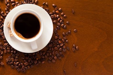 Premium Photo Coffee Cup And Beans On Wooden Table