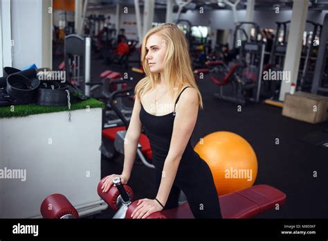 Blonde Girl Posing In The Gym She Wears Dark Pants And Black T Shirt