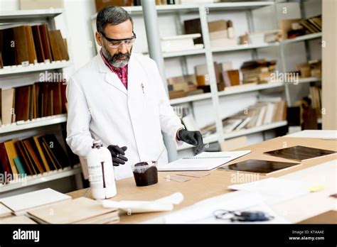 Handsome Mature Engineer Testing Colors On Wooden Specimens In The