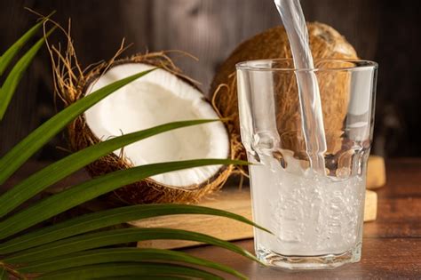 Premium Photo Glass With Fresh Coconut Water And Coconuts On The Table