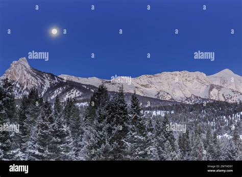 Full Moon Setting In A Pre Dawn Sky Above The Bridger Mountains Near