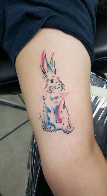 A Tattoo On The Arm Of A Person With A Rabbit In It S Ear