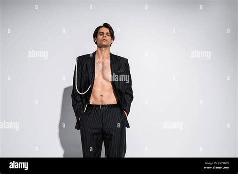 Brunette Model In Trendy Suit With Pearls Posing With Hands In Pockets