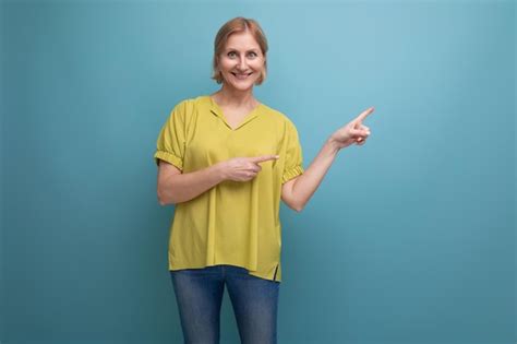 Premium Photo Cute Blonde Middle Aged Woman Showing Empty Space With Her Finger