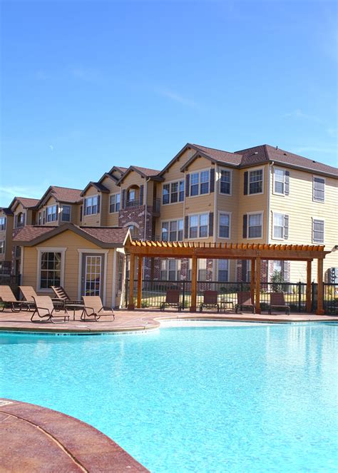 an outdoor swimming pool with lounge chairs around it