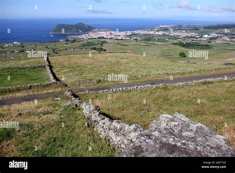 Rural Landscape With Green Pastures And Stone Fences Sloping Toward