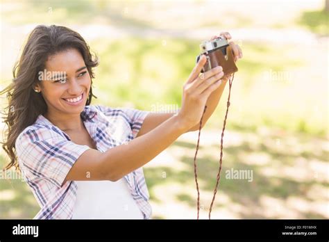 Pretty Brunette Taking A Selfie With Retro Camera In The Park Stock Photo Alamy