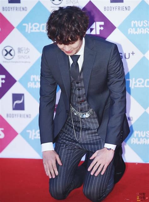 A Man In A Suit And Tie Kneeling Down On The Red Carpet At An Awards Event