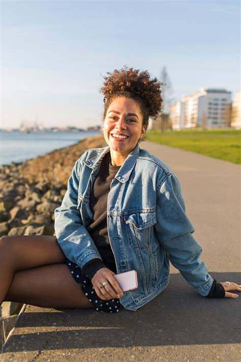 «portrait Of A Young Mixed Race Woman Sitting Using Her Phone Del