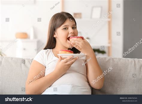 Стоковая фотография 2088792541 Overweight Girl Eating Unhealthy Doughnuts Home Shutterstock