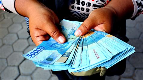 hand holding a pile of fifty thousand rupiah banknotes 46977218 Stock