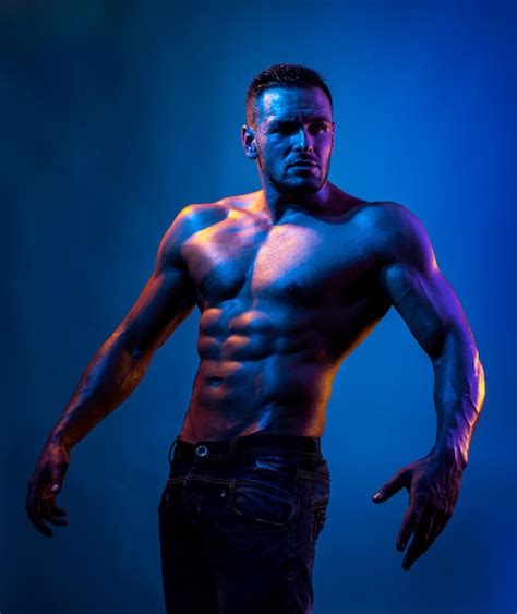 Hombre sexy con cuerpo musculoso y torso desnudo luz de neón azul