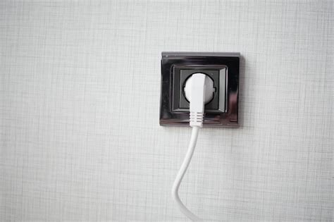 Premium Photo White Color Power Cord Cable Plugged Into Wall