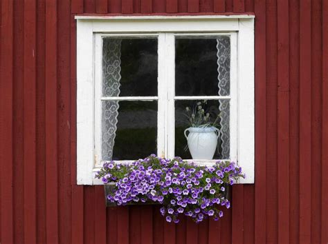 Flower Box Placed Against A Swedish Home Painted In Traditional Red