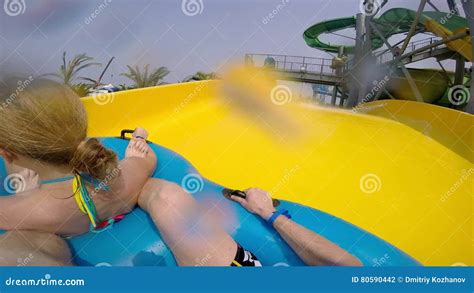 Happy Man And Woman Riding Down The Water Slide People Having Fun In