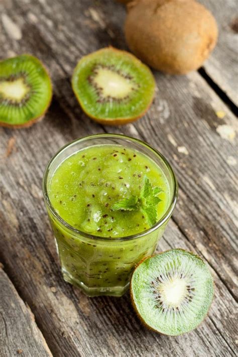 Glass Of Kiwi Juice With Fresh Fruits On Wooden Table Stock Photo