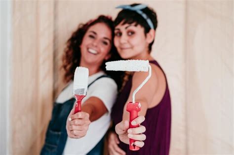 Premium Photo Happy Lesbian Couple Painting The Room Walls With White Color Do It Yourself And