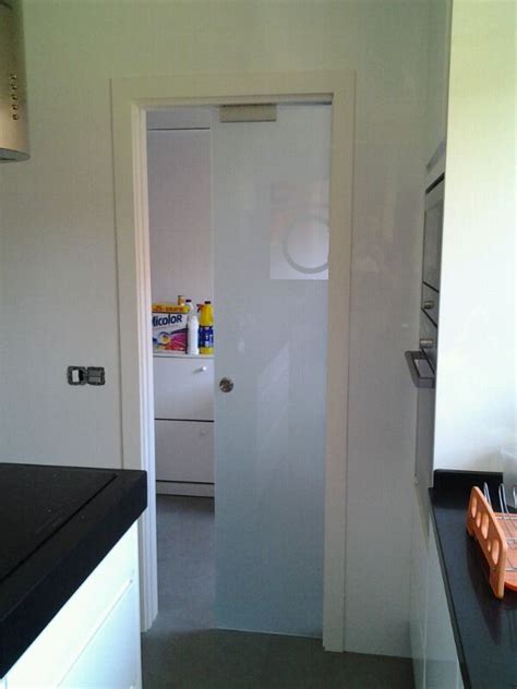 An Open Door Leading To A Kitchen With Black Counter Tops And White Cabinets In The Background