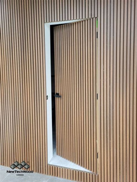 An Open Door On The Side Of A Building With Vertical Slatted Wood Siding