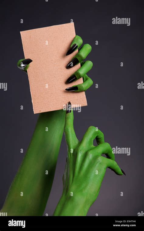 Green Monster Hands With Black Nails Holding Blank Piece Of Cardboard