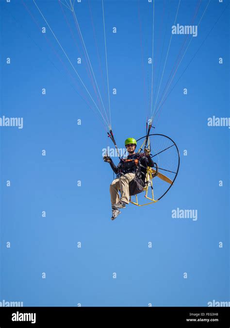 A Close Up Of A Man Flies In His Paramotor Ultralight In The Air By The