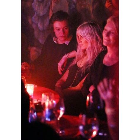 A Group Of People Sitting At A Table In A Dimly Lit Room With Candles