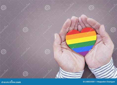 Los Corazones Arcoiris Simbolizan El Orgullo Gay Y Lgbt En Una Mano Humana Imagen De Archivo