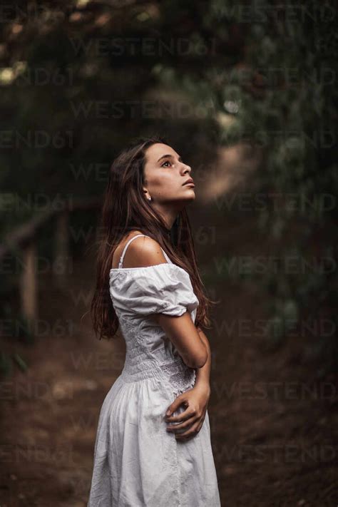 Side View Of Tender Gorgeous Young Woman In White Dress Embracing