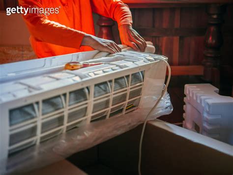 Air Conditioning Technicians Prepare To Install New Air Conditioner In