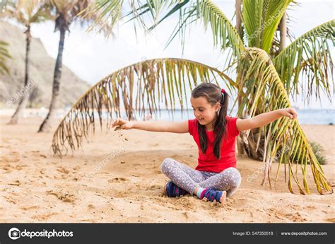 Une petite fille mignonne joue sur une plage près d un palmier image