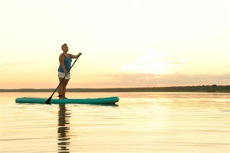 Premium Photo A Woman In Mohawk Shorts Stands On A Sup Board At