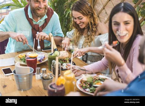 Young People Eating Brunch And Drinking Smoothies Bowl With In Eco Bar