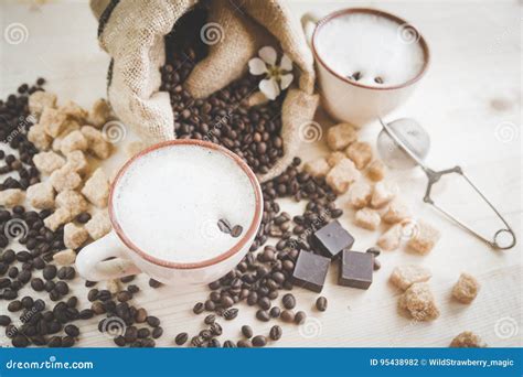 Two Cups Of Freshly Brewed Frothy Cappuccino Spilled Coffee Grains