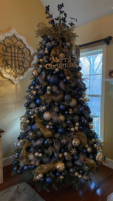 A Christmas Tree Decorated With Blue And Gold Ornaments