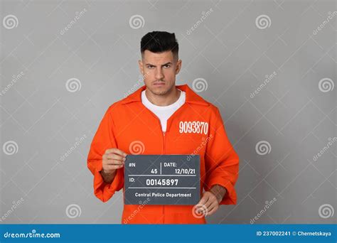 Mug Shot of Prisoner in Orange Jumpsuit with Board on Grey Background ...