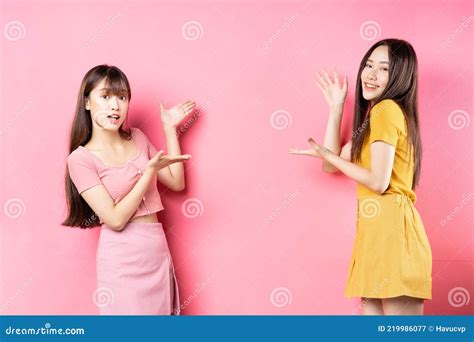 Portrait De Deux Belles Jeunes Filles Asiatiques Posant Sur Fond Rose