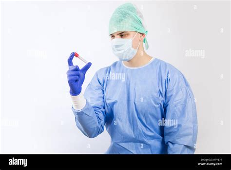 Surgeon Doctor In Sterile Gloves Looking At Ampoule Test Tube He Is