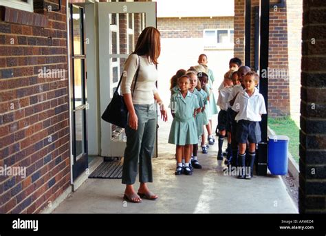 School children lining up outside classroom with teacher Johannesburg ...