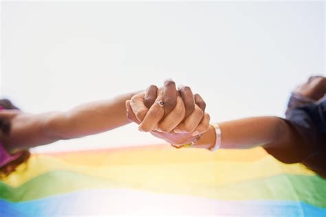 Arco íris da bandeira lgbtq e casal de mãos dadas pelo orgulho gay