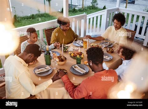 Vue en grand angle de la famille afro américaine en disant grâce à la