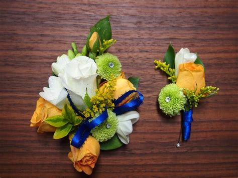 Two Bouquets Of Flowers Sitting On Top Of A Wooden Table