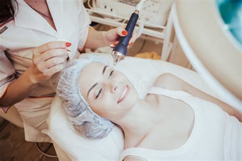 Cosmetology Doctor Makes The Procedure A Woman Face Cleaning Stock