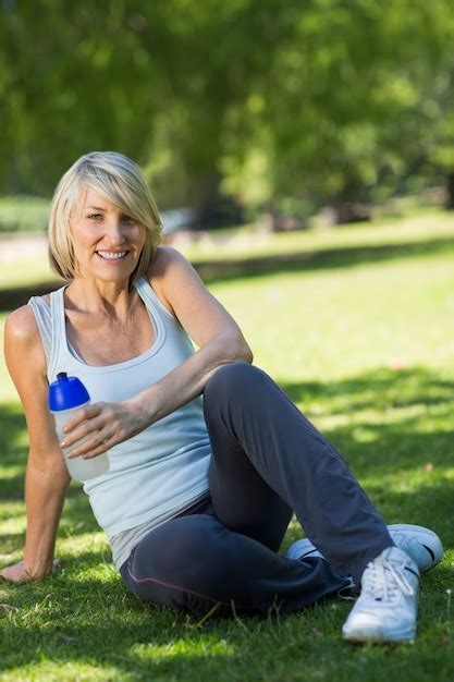 Deportiva Mujer Sosteniendo La Botella De Agua En El Parque Foto Premium