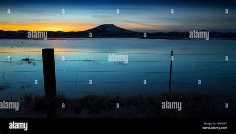 Campo inundado al atardecer con vallado y alambre de púas Sierra del