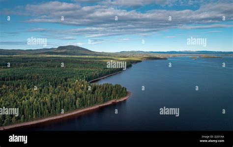 Forest and lakeshore at Lake Siljan from above with blue sky in Dalarna ...